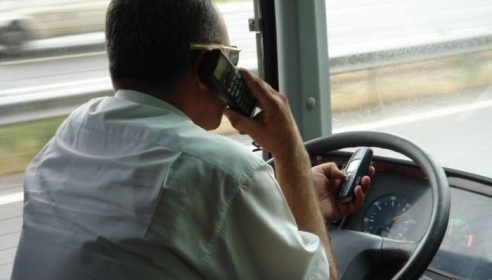 Водитель автобуса говорит по телефону