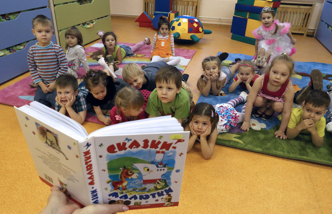 Воспитатель читает детям сказку в комнате отдыха
