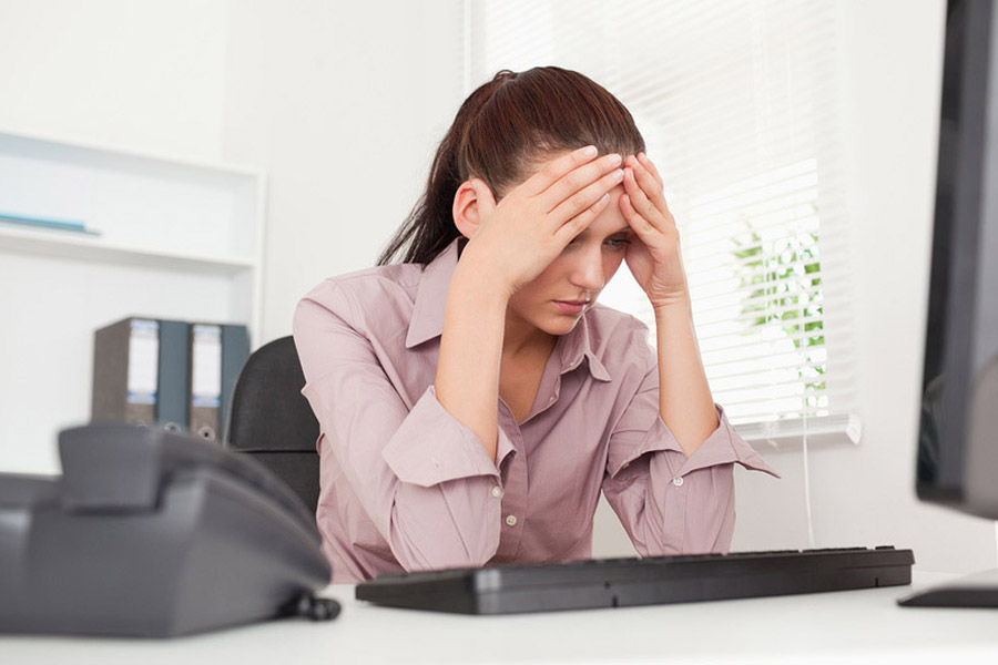 Деловая женщина в депрессии сидит за рабочим столом в офисе